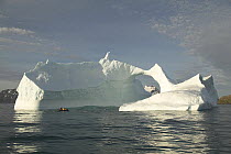 The crew of yacht "Shaman" in the yacht's tender, heading towards a natural arch in an iceberg, south coast of South Georgia.