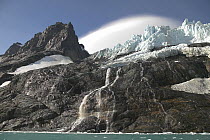 Lenticular clouds in Drygalski Fjord, at the south-eastern tip of South Georgia.^^^The dramatic steep sided fjord flanked by the snow-covered jagged volcanic peaks of the Salvesen Range provide the ba...