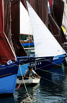 Young children skulling a tender at a classic wooden boats rally in La Foret Fouesnant, Brittany, France.