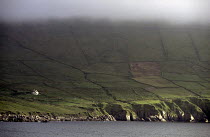 Low cloud over a lone house on the Beara Peninsula. Munster, Ireland.
