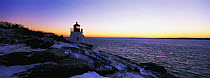 Castle Hill Lighthouse surrounded by snow under a wintery sunset. Established in 1890, the lighthouse marks the East Passage into Narragansett Bay, near Newport, Rhode Island, USA.
