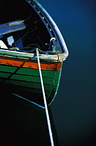 Bow of a traditional clinker dinghy with taught rope.