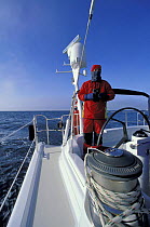 Crew member aboard "Shaman" wearing warm clothes as he stands watch near Spitsbergen, Svalbard, Norway, 1998.