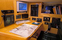 Chart table and navigation station on a large yacht with inbuilt computers and instruments.