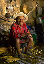 Local man weaving grass mats in his home by the shore of Lake Atitlan, Guatemala.