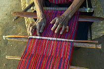 Using a loom to hand weave traditional fabrics, Guatemala.