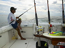 Man fishing for yellowfin tuna (Thunnus albacares) off the stern of a boat, Guatemala.