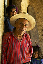 Father, daughter and granddaughter standing by a doorway, Guatemala.