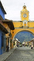 Old clock tower and colourful buildings on the cobbled streets of Antigua, Guatemala.