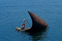 Local people sailing a dhow, a traditional sailing vessel.
