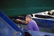 Eric Tabarly antifouling the bottom of his classic yacht "Pen Duick".