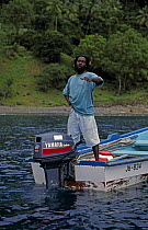 Rastafarian man in a fishing boat, Caribbean.