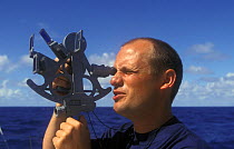 A man navigating by Sextant, a measuring instrument generally used to measure the angle of elevation of a ^^^celestial object above the horizon. Making this measurement is known as sighting the object...
