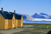 Mountains and a glacier with cottages in the foreground, Longyearbyen, Spitsbergen, SValbard, Norway.
