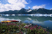 Bear Glacier and mountains with two Klepper kayaks tethered to shore, Kenai Fjords National Park, Kenai Peninsula, Alaska.