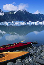 Mountains and Bear Glacier with Klepper kayaks tethered to the shore, Kenai Fjords National Park, Kenai Peninsula, Alaska.