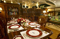 Set dinner table in the stunning interior aboard a luxury superyacht.