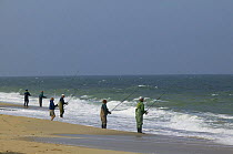 Fishermen with rods lined up along the shore.