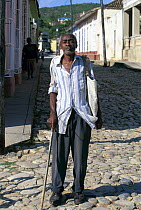 Local man with stick, smoking a cigar, Trinidad, Cuba.