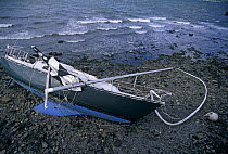 Wrecked boat washed up on a stony shore, 1999.