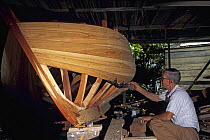Boatbuilder at work on a wooden hull, Bahamas.