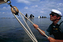 Trimming the jib on board a traditional sailing cargo boat called a Skutsje, on a lake during Skutjesilen, Friesland, Netherlands, 1991.