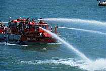 Fire rescue boat firing water from hoses, Newport, Rhode Island, USA.