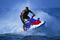 A man spinning a jet ski in the water.