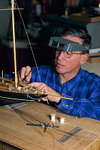 A model yacht maker adding detail to a scale-model of the 1915 Herreshoff schooner "Mariette".
