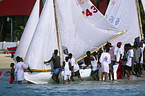 Locals helping to launch a local fishing boat for racing at the Grenada Sailing Festival, Grenada, Caribbean.