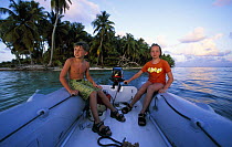 Two boys sitting in a yacht tender, Belize. Model released.