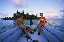 Two boys sitting in a yacht tender, Belize.
