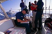 US Coastguard on board a yacht carrying out routine checks, off Boston, USA.