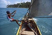 Kuna Indian boys sailing in a Cayuca canoe, Chichime Cays, San Blas Islands, Caribbean.