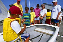 Children learing how to tie a figure of eight knot at a sailing school in Newport, Rhode Island, USA.