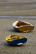Wooden clinker built tenders lying on the mud at low tide, South Island, New Zealand.