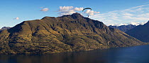 Parascending over a fjord, South Island, New Zealand.
