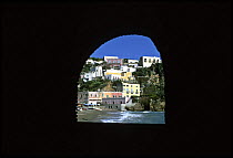 Looking through an archway onto a seafront village on the Mediterranean island of Ponza, Bay of Naples, Italy.