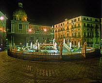 Fountain in Piazza Pretoria, Palermo, Sicily, illuminated at night.
