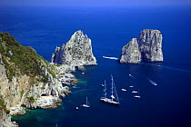 Yachts moored near Faraglioni, a group of rocks on jagged coast of Capri, Italy. This view is from Monte Solaro.