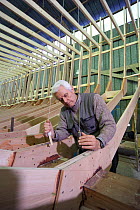 Shipwright at work with a plumb line during construction of a 38-metre wooden motorboat, at a boatbuilders in Fiumicino, Rome. ^^^It is rare today to see big boats such as this made of wood.