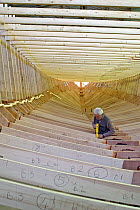 Shipwright at work during construction of a 38-metre wooden motorboat, at a boatbuilders in Fiumicino, Rome. ^^^It is rare today to see big boats such as this made of wood.