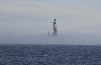 Drilling rig shrouded in fog, North Sea. May 2005.