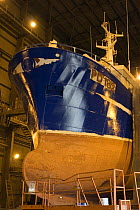 Fishing vessel undergoing painting and maintenance in an enclosed ship lift facility at Peterhead harbour. May 2005.