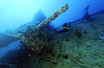 Diver beside cannon on the wreck of the SS Thistlegorm, a sunken war ship located in the Straits of Gubal, Northern Red Sea. She was sunk by German bomber planes in World War II ^^^and has lain at the...