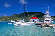 Yachts and a large, luxury fishing boat moored alongside the pier and fuel station at Marina Cay, British Virgin Islands (BVI)