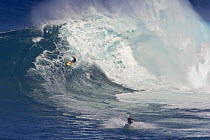 A tow-in surfer and jetski at Peahi (Jaws) off Maui. Hawaii.