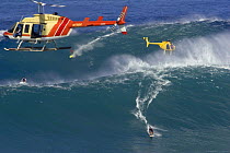 Helicopters filming tow-in surfers at Peahi (Jaws) off Maui, Hawaii.