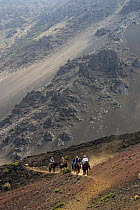 Horse riders on trail out of Haleakala Crater, Maui's dormant volcano, Hawaii. Model released.