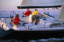 Crew aboard a race yacht trimming the sails on a beautiful evening off the east coast, USA.